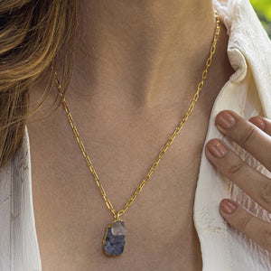 A person wearing a gold-plated chain necklace with an Abstract Gemstone Pendant (VNK0005) by Vanya Lara.