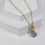 A person wearing a gold-plated chain necklace with an Abstract Gemstone Pendant (VNK0005) by Vanya Lara.