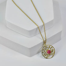 Load image into Gallery viewer, Golden Lotus Necklace by Vanya Lara with lotus detail and raw pink gemstones displayed on a white stand.
