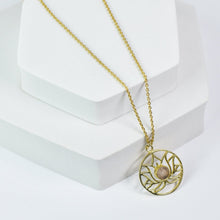 Load image into Gallery viewer, Golden Lotus Necklace by Vanya Lara with lotus detail design and gemstones on a white display stand.
