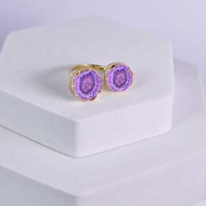 A ring with dual purple geode stones set in gold, displayed on a white pedestal, now part of our exclusive Solar Quartz Ring - VRG0001 collection by Vanya Lara.