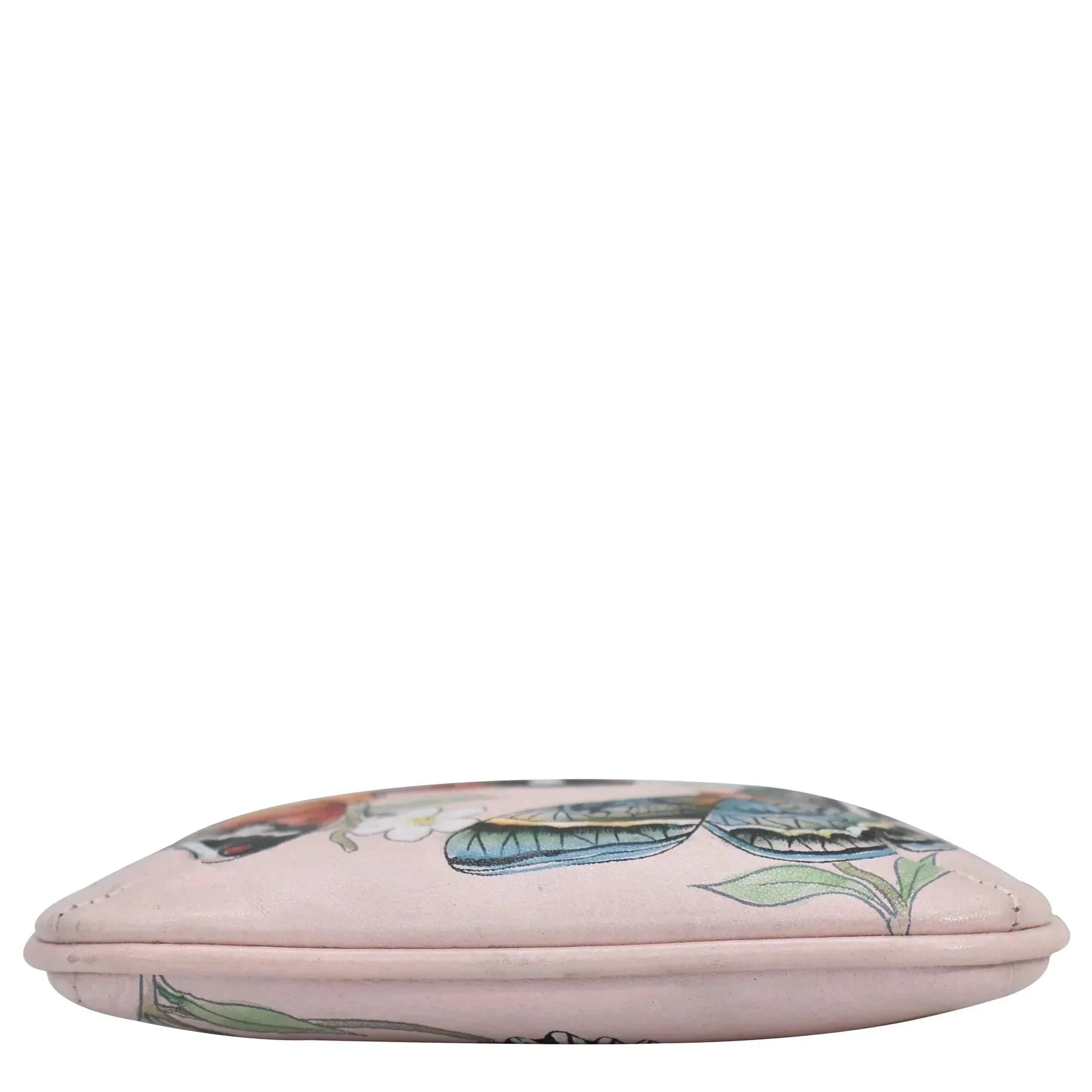 Colorful patterned Anuschka leather cushion isolated on a white background.