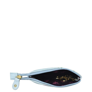 A small, Anuschka genuine leather open white wristlet with a floral interior pattern and a golden zipper visible.