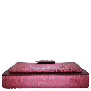 Red embossed genuine leather Anuschka ottoman with a matching cushion on top.