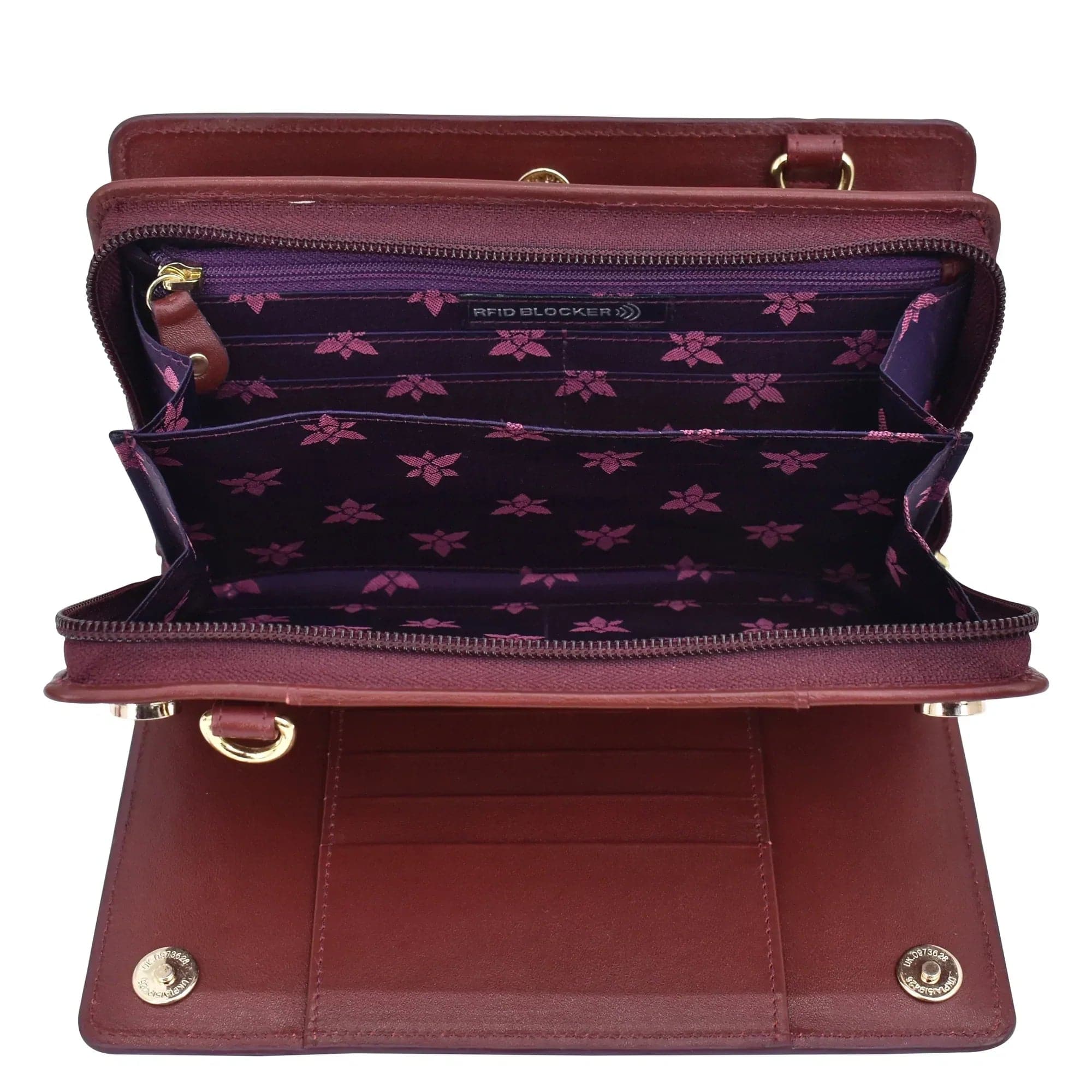 An open brown genuine leather Organizer Wallet Crossbody - 1149 with multiple compartments and a purple interior featuring a floral pattern and RFID protection by Anuschka.