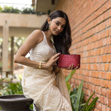 Load image into Gallery viewer, A woman in traditional attire posing with an Anuschka Organizer Wallet Crossbody - 1149 against a brick wall.
