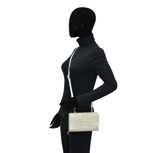 Mannequin dressed in black attire with a Anuschka Organizer Wallet Crossbody - 1149 and a white purse.