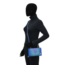 Load image into Gallery viewer, Mannequin with black full-body suit and featureless head, holding a Anuschka Organizer Wallet Crossbody - 1149 with RFID protection.
