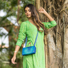 Load image into Gallery viewer, Woman in green traditional dress standing by a tree with an Anuschka Organizer Wallet Crossbody - 1149 featuring RFID protection.
