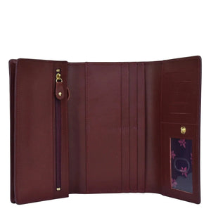 Open Anuschka chic burgundy genuine leather three fold wallet showcasing multiple card slots and a zippered coin pocket.