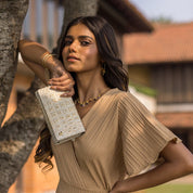Woman posing with an Anuschka Three Fold Wallet - 1150 outdoors.