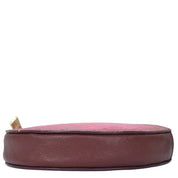 A side view of an empty, Anuschka Round Coin Purse - 1175 in genuine leather maroon on a white background.
