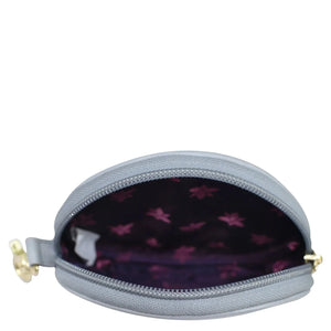 A gray genuine leather Round Coin Purse - 1175 by Anuschka with an open zipper revealing a purple interior with a hand-painted floral pattern.