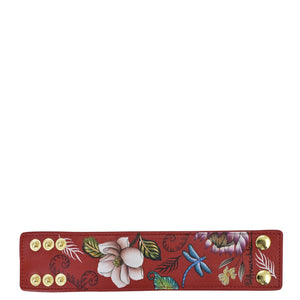 Hand painted, floral patterned red Anuschka genuine leather wallet with multiple snap buttons.