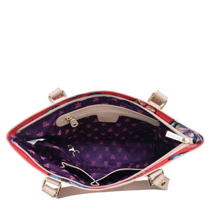 Open Anuschka handbag displaying the interior fabric and zippered pocket.