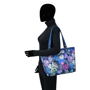 Mannequin dressed in black with a colorful marine-themed Anuschka Fabric with Leather Trim Zip Top City Tote - 12005 featuring a leather shoulder strap.