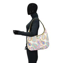 Load image into Gallery viewer, Mannequin wearing a paisley patterned Fabric with Leather Trim Large Sling Hobo - 12010 by Anuschka with zippered pockets.
