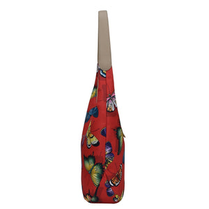 Colorful butterfly print Anuschka tote bag with shoulder strap on a white background.