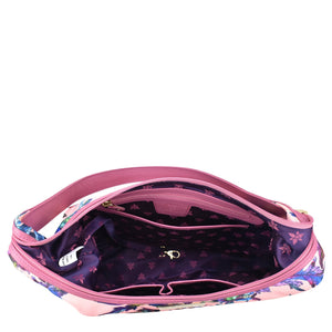 Open Anuschka floral-patterned waist bag showing empty interior with zippered pockets and zipper closure.