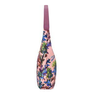 A floral-patterned, pink Anuschka yoga mat bag with a shoulder strap and zippered pockets.
