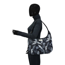 Load image into Gallery viewer, A mannequin with a full facial covering models an Anuschka Fabric with Leather Trim Large Sling Hobo - 12010, featuring an adjustable shoulder strap, against a white background.
