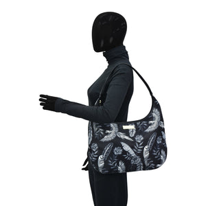 A mannequin with a full facial covering models an Anuschka Fabric with Leather Trim Large Sling Hobo - 12010, featuring an adjustable shoulder strap, against a white background.