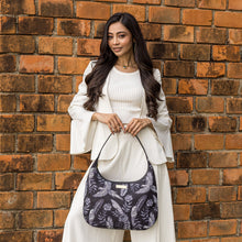 Load image into Gallery viewer, Woman posing with an Anuschka Fabric with Leather Trim Large Sling Hobo - 12010 featuring a zippered pocket against a brick wall.

