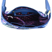 Load image into Gallery viewer, An overhead view of an open, empty Anuschka Fabric with Leather Trim Large Sling Hobo - 12010 handbag with a star-patterned interior lining and a zippered pocket.
