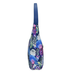 Colorful printed Anuschka sling bag with a zippered pocket on a white background.