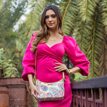Load image into Gallery viewer, Woman in a pink dress posing with an Anuschka Fabric with Leather Trim East/West Hobo - 12013 featuring an adjustable handle drop.
