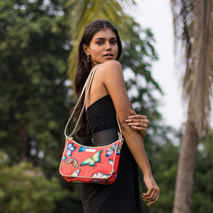 A woman with an Anuschka Fabric with Leather Trim East/West Hobo - 12013 featuring a butterfly print and an adjustable handle drop poses outdoors.