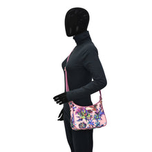 Load image into Gallery viewer, Mannequin dressed in black with a Floral Shoulder Bag featuring an adjustable handle drop by Anuschka.
