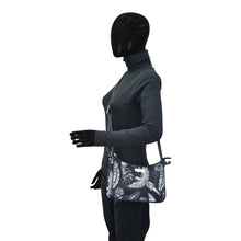 Load image into Gallery viewer, Person in an Anuschka bodysuit and gloves with a black mask covering the entire head, holding an Anuschka Fabric with Leather Trim East/West Hobo - 12013 featuring an adjustable handle drop.
