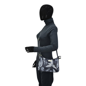 Person in an Anuschka bodysuit and gloves with a black mask covering the entire head, holding an Anuschka Fabric with Leather Trim East/West Hobo - 12013 featuring an adjustable handle drop.