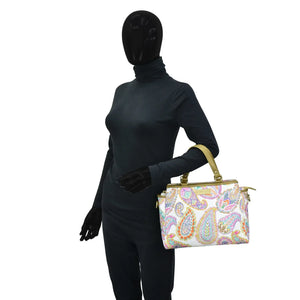 Mannequin in a black bodysuit holding an Anuschka Fabric with Leather Trim Multi Compartment Satchel - 12014 with an adjustable strap.