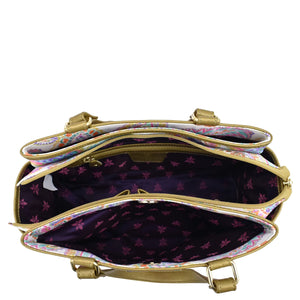 Open Anuschka handbag displaying interior compartments, zippered compartment, and lining.