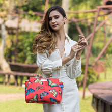 Load image into Gallery viewer, Woman with a Anuschka Fabric with Leather Trim Multi Compartment Satchel - 12014 handbag featuring a zippered compartment, standing in a park.
