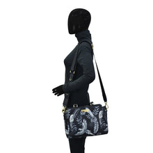 Load image into Gallery viewer, Sentence with replaced product: Mannequin with black head displaying a Anuschka Fabric with Leather Trim Multi Compartment Satchel - 12014 with an adjustable strap.
