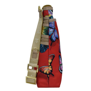 Colorful butterfly print on a Anuschka fabric with leather trim crossbody bag with an adjustable handle and a rear zippered pocket.