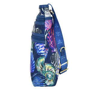 Anuschka fabric with leather trim crossbody bag with slip pocket, featuring marine life patterns and an adjustable handle, isolated on a white background.