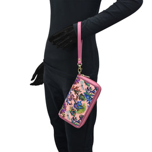 Person wearing black attire with black gloves holding a floral pink Anuschka Fabric with Leather Trim Wristlet Travel Wallet - 13000.