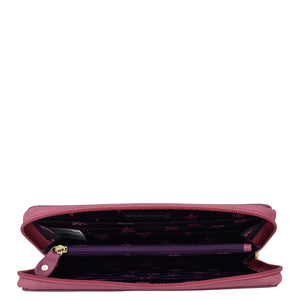 An open, empty pink Anuschka Fabric with Leather Trim Wristlet Travel Wallet - 13000 with a floral pattern inside, isolated on a white background.