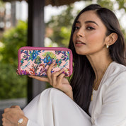 Woman showcasing an Anuschka Fabric with Leather Trim Wristlet Travel Wallet - 13000 with RFID protection.