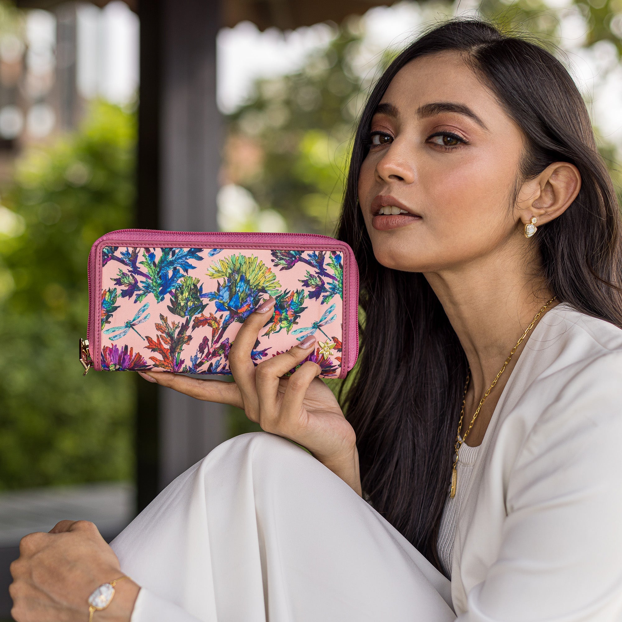 Woman showcasing an Anuschka Fabric with Leather Trim Wristlet Travel Wallet - 13000 with RFID protection.