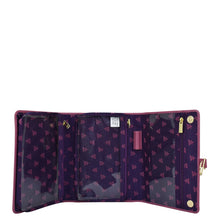 Load image into Gallery viewer, Open Anuschka fabric with leather trim toiletry case with multiple card slots and a zipper compartment, featuring a snap button closure and a pattern of stars and logos.

