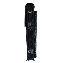 Load image into Gallery viewer, Side view of a black Anuschka umbrella with a decorative pattern, closed and secured with a crossbody strap.
