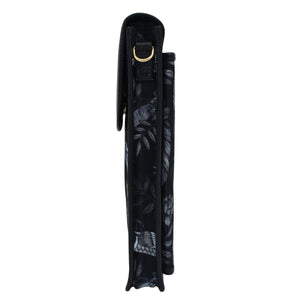 Side view of a black Anuschka umbrella with a decorative pattern, closed and secured with a crossbody strap.