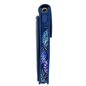 Side view of a rolled-up Anuschka blue yoga mat with a patterned design and crossbody strap.