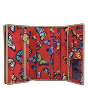 Colorful butterfly-patterned Anuschka Fabric with Leather Trim Three-Fold RFID Wallet - 13007 with multiple card slots, zip pockets, and RFID protected.