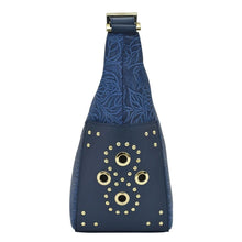 Load image into Gallery viewer, Anuschka Classic Hobo With Studded Side Pockets - 433 with navy blue leather crossbody bag with floral pattern and circular metallic embellishments.
